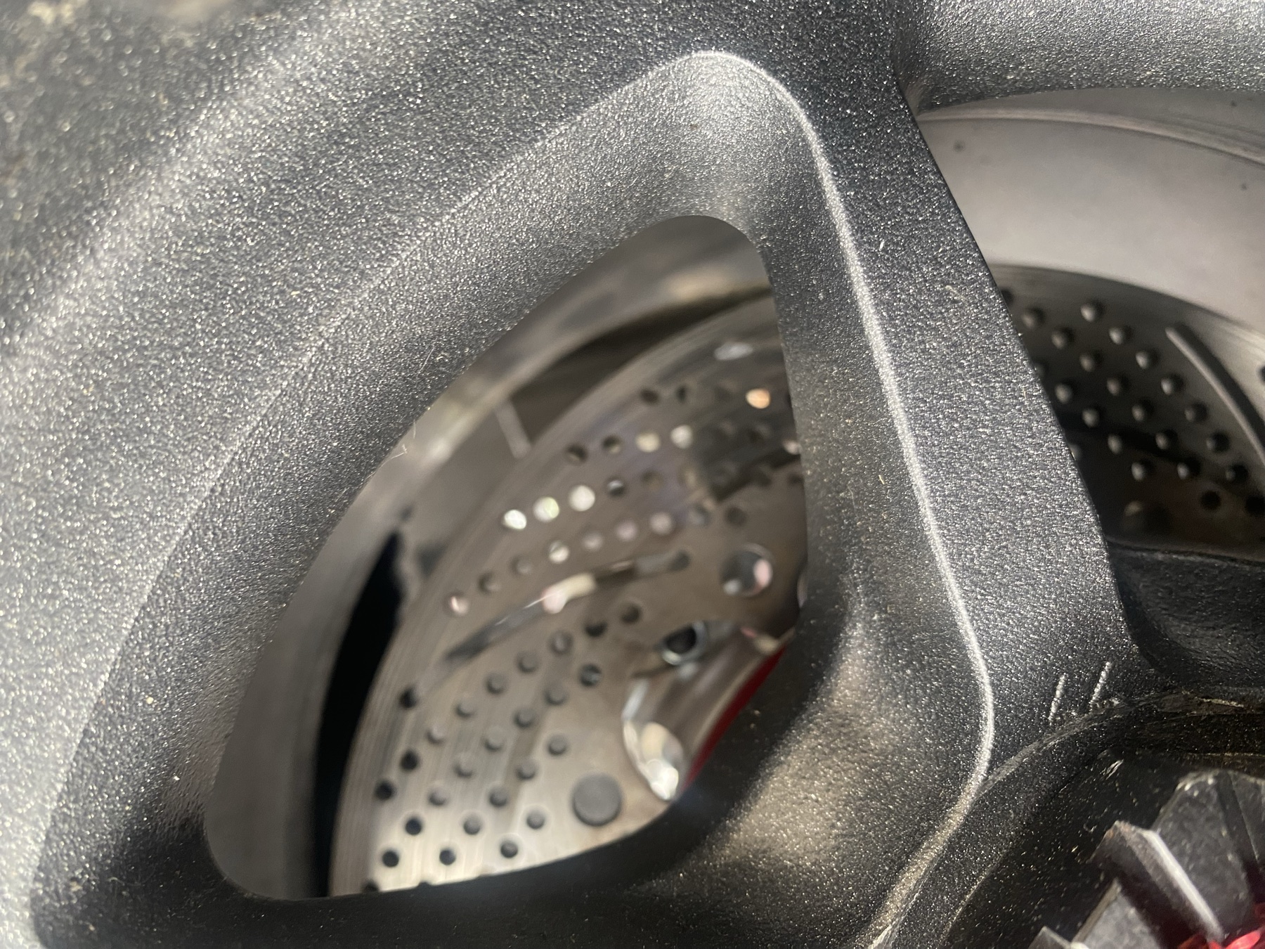 Drilled steel brake rotor visible through the OZ Racing wheel spokes