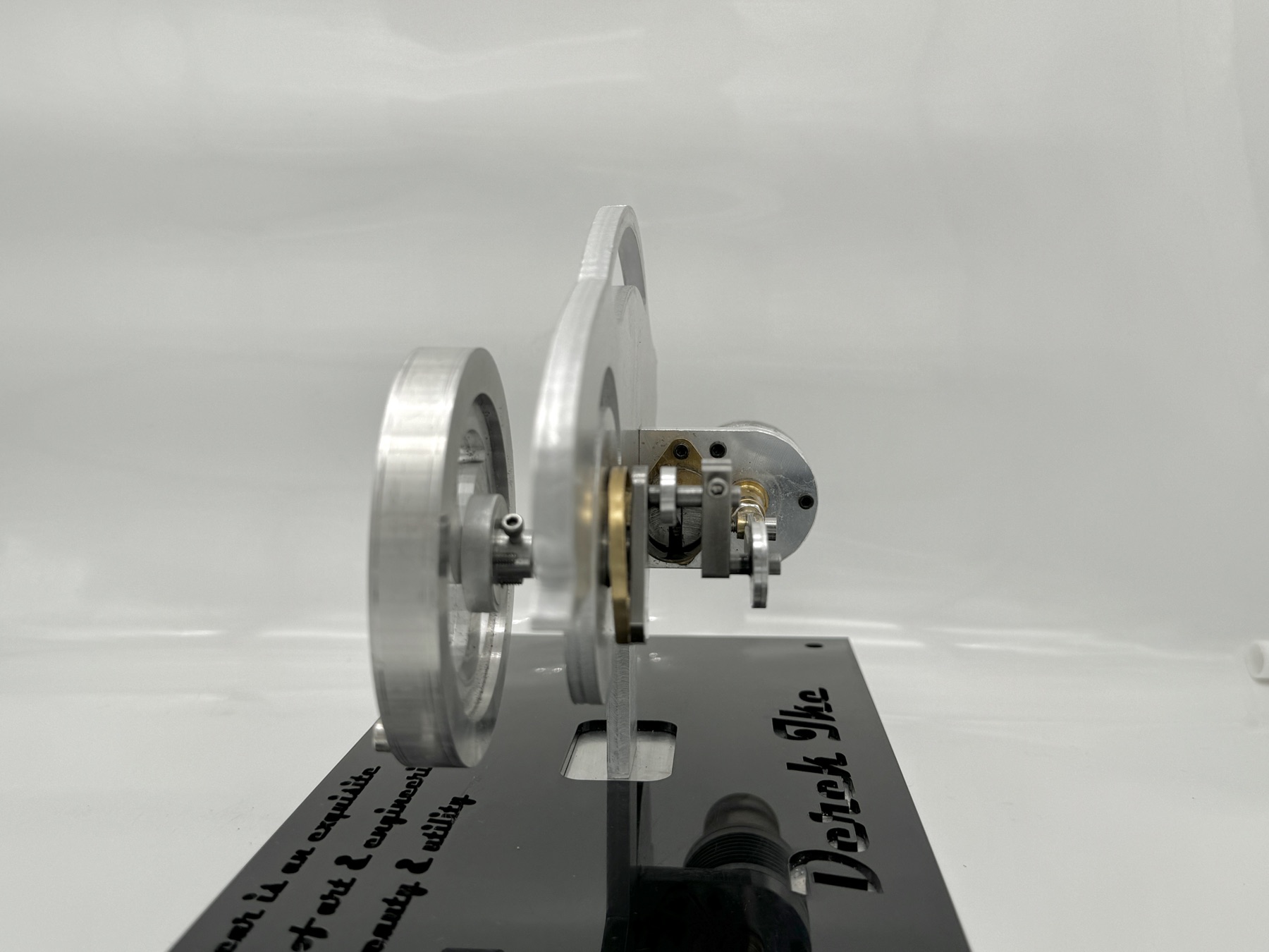 Three-quarter view of the finished engine showing the aluminum flywheel and the crank linkage